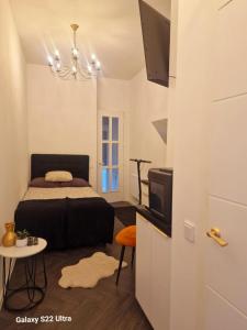 een slaapkamer met een bed, een tv en een tafel bij Kaunas Studios - RentA Studio 16 in Kaunas