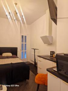 een slaapkamer met een bed en een keuken met een aanrecht bij Kaunas Studios - RentA Studio 16 in Kaunas