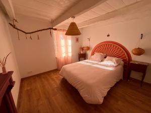 una camera da letto con un letto grande con testiera in legno di Ti ar Goanag, Maison de vacances, Séjour, Week-end a Pleyben