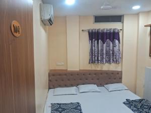 a bedroom with a bed and a window at Hotel Ruby in Ujjain