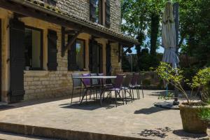 a patio with a table and chairs and an umbrella at Domaine Belle Ombre in Montbellet