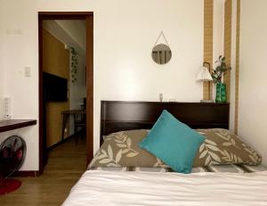 a bedroom with a bed with a blue pillow on it at Althea's Cozy Apartment in Manila