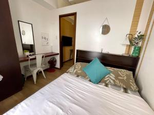a bedroom with a bed and a desk and a mirror at Althea's Cozy Apartment in Manila +44 photos