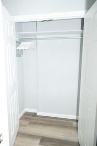 an empty closet with white walls and a door at Ruby Room at Brighton Beach 2-Min Walk to Ocean & Subway Chic Stay in Brooklyn +5 photos
