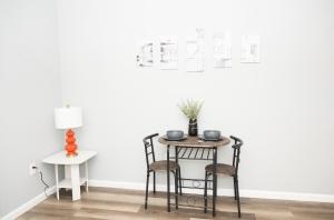 a table and chairs in a room with a white wall at Ruby Room at Brighton Beach 2-Min Walk to Ocean & Subway Chic Stay in Brooklyn