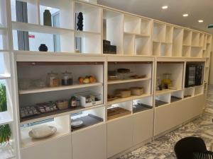 a kitchen with white cabinets with food in it at Hotel Areosa in Porto