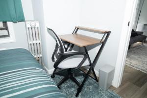 - un bureau dans une chambre à côté d'un lit dans l'établissement Emerald Room at Brighton Beach 2Min Walk to Ocean n Subway Chic Stay, à Brooklyn