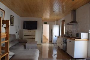 a kitchen and living room with a couch and a tv at EL CHORRO Aire acondicionado Bar privado Barbacoa Amplios patios in Castalla