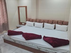 a bed with two pillows on it in a room at Hotel Ruby in Ujjain
