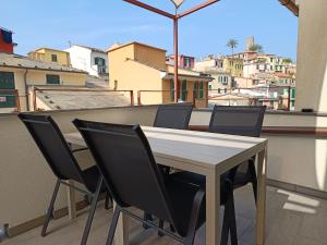 stół i krzesła na balkonie z widokiem w obiekcie Santa Marta Rooms - Vernazza w mieście Vernazza