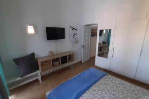 sala de estar con TV y alfombra azul en Vistas de Ensueño al Mar en Playa del Águila, en Playa del Águila