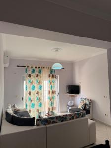 a living room with a couch and a window at Mateos Apartment Saranda in Sarandë