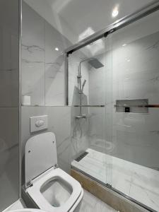 a white bathroom with a toilet and a shower at Guesthouse Enea in Durrës +52 photos