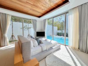 a living room with a couch and a tv and windows at Modern 3BR Pool Villa near Laguna- Lux Pride 4 by Warm Plus in Ban Pak Lak