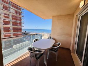 a balcony with a table and chairs and a view of the ocean at Residencia Dos Mares I, Bloque 3, Escalera 1, 2º C in La Manga del Mar Menor
