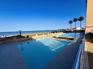 a swimming pool with the beach in the background at Residencia Dos Mares I, Bloque 3, Escalera 1, 2º C in La Manga del Mar Menor