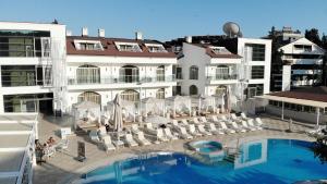 Un hotel con piscina y sillas y un edificio. en Forum Residence Hotel, en Marmaris
