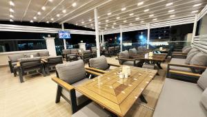 un restaurante con mesas y sillas de madera, mesa y sillas en Forum Residence Hotel, en Marmaris