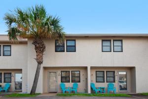 a building with blue chairs and a palm tree at Beach Rendezvous in Navarre