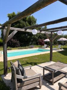 a wooden pergola with a chair and a table next to a pool at Casa Anna in Villach