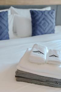 two folded towels sitting on a bed at 1412 Wyndham Gardens Elegant Pool Condo in Nai Thon Beach