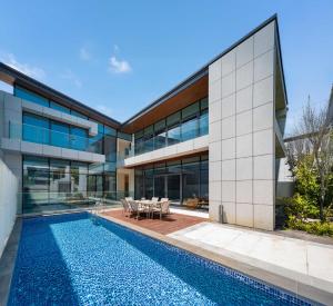 an exterior view of a building with a swimming pool at 三亚海棠湾蔚蓝海湾公寓 in Sanya