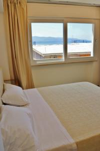 Un dormitorio con una cama blanca y una ventana. en Scilla Luxury Rooms, en Scilla