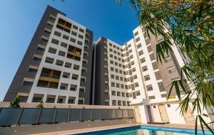 two tall buildings with a pool in front of them at Stay comfort at City Heart 2Bhk AC ,WIFI & Much more in Indore