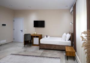 a bedroom with a bed and a desk and a television at Vila Erti Berat in Berat