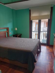 a bedroom with a bed in a room with green walls at Apartamento 2 habitaciones con garaje in Gondomar
