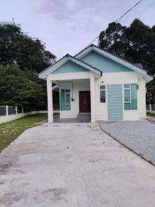 ein kleines blaues und weißes Haus mit Auffahrt in der Unterkunft Villa Mun Homestay with 3 bedrooms 3 bathrooms in Kota Bharu