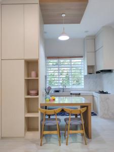 eine Küche mit einem Holztisch und zwei Stühlen in der Unterkunft Villa Mun Homestay with 3 bedrooms 3 bathrooms in Kota Bharu + 3 Fotos
