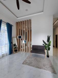 ein Wohnzimmer mit Sofa und Tisch in der Unterkunft Villa Mun Homestay with 3 bedrooms 3 bathrooms in Kota Bharu