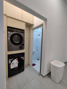 eine Küche mit Mikrowelle und einer Tür zu einem Zimmer in der Unterkunft Villa Mun Homestay with 3 bedrooms 3 bathrooms in Kota Bharu