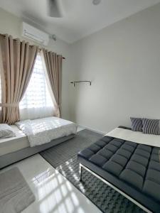 ein Schlafzimmer mit zwei Betten und einem Fenster in der Unterkunft Villa Mun Homestay with 3 bedrooms 3 bathrooms in Kota Bharu