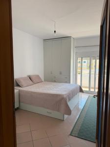 a bedroom with a bed with pink pillows on it at Vollga Escape Sea View in Durrës