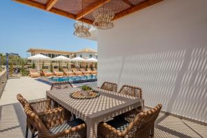 a patio with a table and chairs and a pool at Boheme Villas close access to Laganas Resort in Zakynthos Town