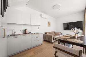 a kitchen and dining room with white cabinets and a table at Dunique in Palanga