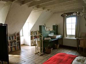 a attic room with a desk and a window at Holiday Home Stilleven in Veurne