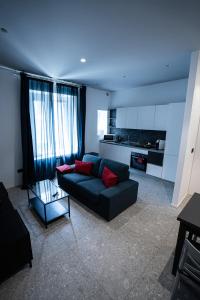 Una sala de estar con un sofá y una cocina. en De Luca 6 Apartments - Vinto House Collections, en Salerno