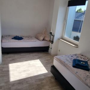 a small room with two beds and a window at Ferienwohnung zur Schmiede in Prödel