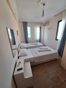 a small room with two beds and a mirror at Golden Beach Hotel in Didim