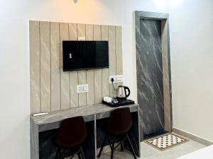 a room with two chairs and a television on a wall at The Grand Luxury Stay Hotel in Agra +23 photos
