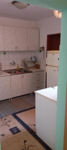 a kitchen with white cabinets and a white refrigerator at Apartman Kuršumlijska Banja in Kursumlijska Banja
