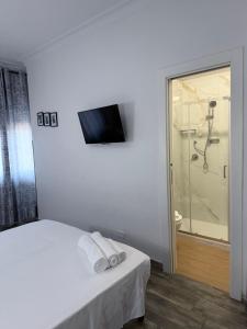 ein Schlafzimmer mit einem Bett, einer Dusche und einem TV in der Unterkunft Tiburtina Hotel Holiday in Rom