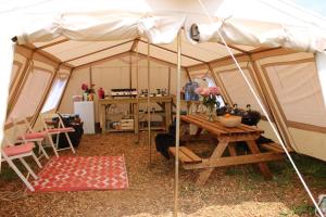 a tent with a wooden table and a table sidx sidx sidx at Hidden Valley Dorset in Powerstock