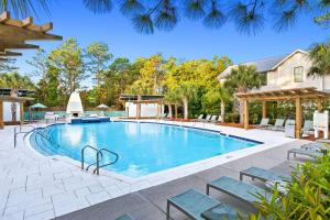 une piscine avec des chaises et une maison dans l'établissement Beachy Bungalow, à Santa Rosa Beach