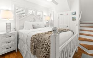 a white bedroom with a white bed with a leopard blanket at Spice in Santa Rosa Beach +27 photos