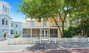 a large yellow house with a white fence at Spice in Santa Rosa Beach
