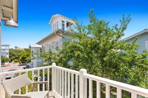 a white porch with a white railing and a tree at Sugar and Spice in Santa Rosa Beach
